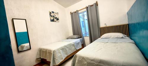 a bedroom with two beds and a mirror at Casa Andy a 5 min del aeropuerto de Veracruz in Veracruz