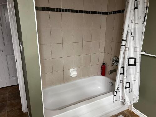 a white bath tub with a shower curtain in a bathroom at Cozy 2BR Getaway Quiet & Relaxing in Langley