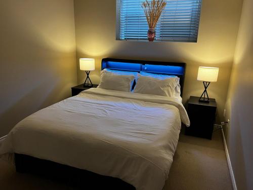 a bedroom with a large white bed with two lamps at Cozy 2BR Getaway Quiet & Relaxing in Langley