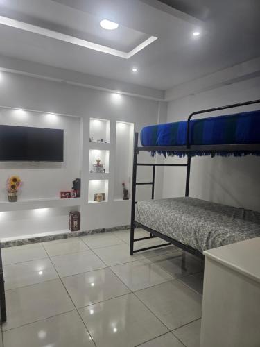 a bedroom with two bunk beds and a flat screen tv at Urban Oasis in Manta