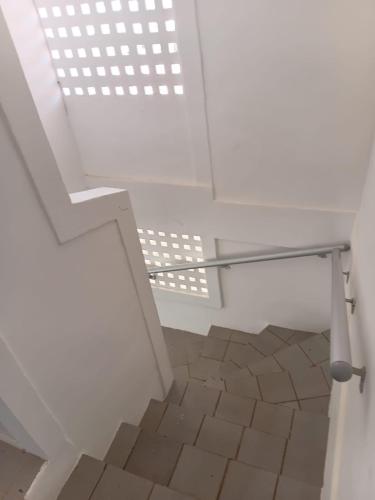 a white staircase with a glass railing and a tile floor at Bonito Itapuama Beach in Cabo de Santo Agostinho