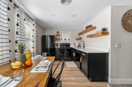 a kitchen with a wooden table and a dining room at NEW! Clearwater Gem, 10 Min to Beach, 2 Min to Downtown Dunedin, King Bed in Clearwater