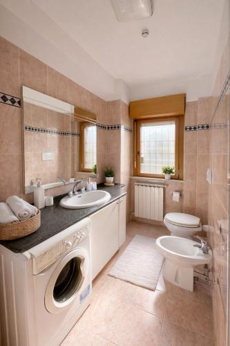 a bathroom with a sink and a washing machine at The Mazzitellis Home in Nettuno