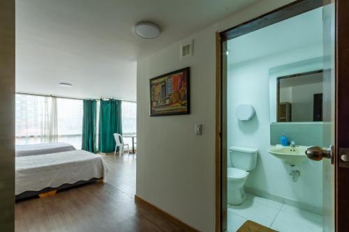 a bedroom with a bed and a sink and a toilet at Hospedaje Sary House in Bogotá