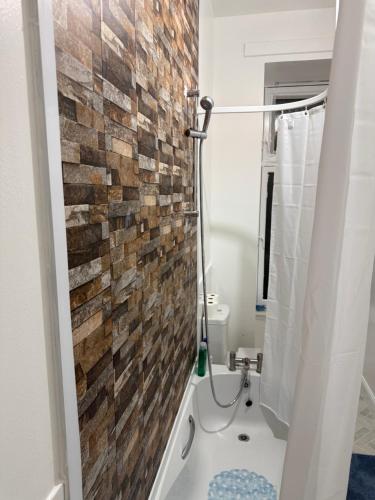 a bathroom with a brick wall next to a toilet at Zikach Apartment Near to Glasgow Airport in Renfrew