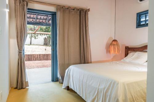 a bedroom with a bed and a window at Casa Pema - Grupo Casa Camurupim in Barra Grande