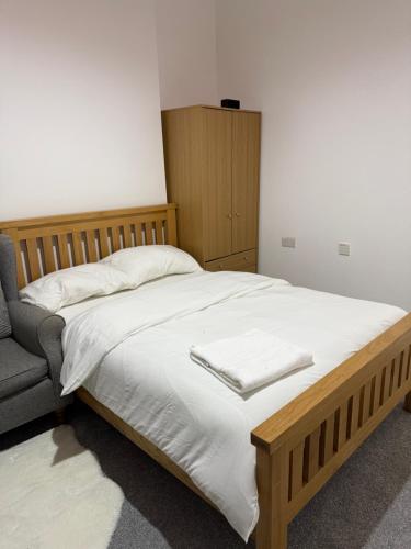 a bedroom with a large bed and a chair at Zikach Apartment Near to Glasgow Airport in Renfrew