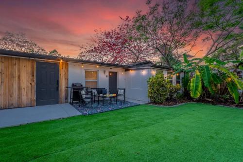 a backyard with a green lawn in front of a house at NEW! Clearwater Gem, 10 Min to Beach, 2 Min to Downtown Dunedin, King Bed in Clearwater