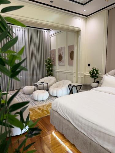 a bedroom with a large bed and two chairs at Damac Al Jawharah Tower Versace Sea View شقة فرزاتشي بإطلالة بحرية برج داماك الجوهرة in Jeddah