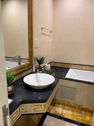a bathroom with a sink and a bath tub at Damac Al Jawharah Tower Versace Sea View شقة فرزاتشي بإطلالة بحرية برج داماك الجوهرة in Jeddah