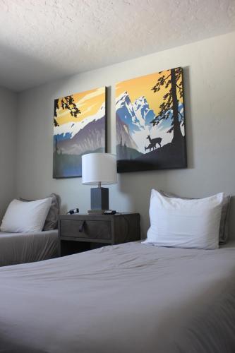 a bedroom with a bed and two paintings on the wall at Palooza Basecamp in Cascade