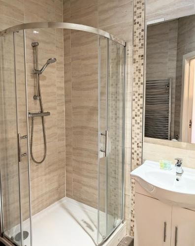 a bathroom with a shower and a sink at Oscar Lodge in Northampton
