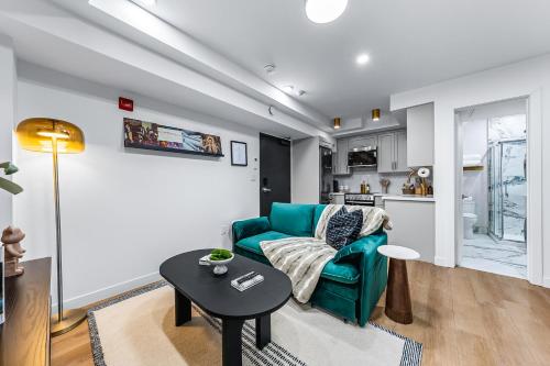 a living room with a green couch and a table at The McCaul by Casa Hotels Near AGO Basement Suite in Toronto