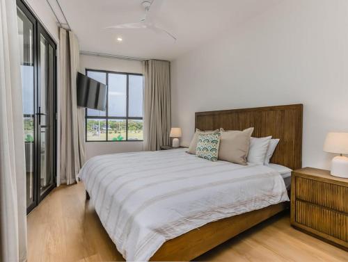 a bedroom with a large bed and a window at Black Wattle Beach House in Casuarina