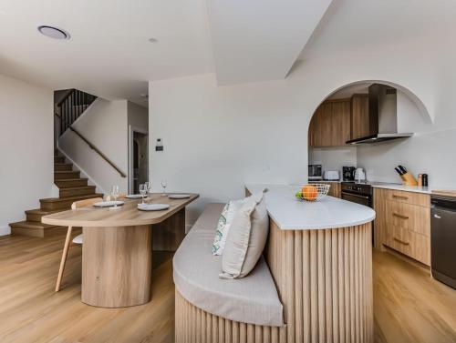 a kitchen with a table and a bench in a room at Black Wattle Beach House in Casuarina