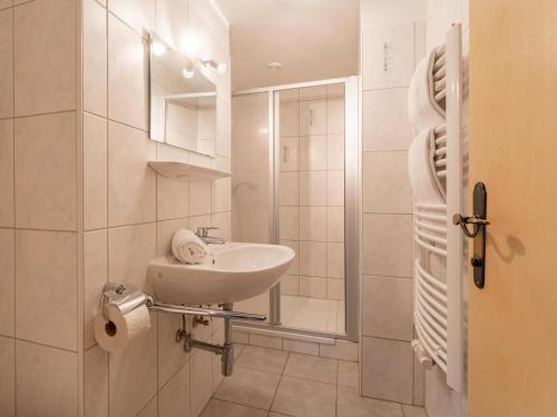 a white bathroom with a sink and a shower at Grieswirt L in Itter