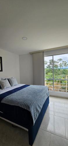 a bedroom with a bed and a large window at Hospedaje en Montenegro Vivienda Turística Cafecito in Montenegro