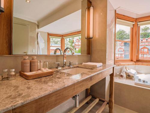 a bathroom with a sink and a large mirror at Hotel Catedral Patagonia Ski & Wellness in San Carlos de Bariloche