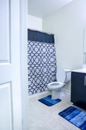 a bathroom with a toilet and a shower curtain at Cozy & inviting 2BD 2BTH Apt Home in Owings Mills