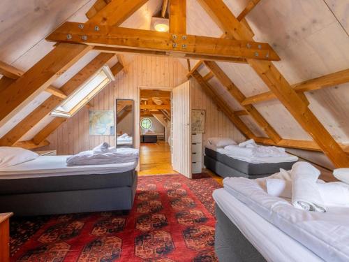 a attic room with two beds and a red rug at De Schuur in Kaag