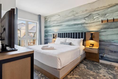 a bedroom with a large bed with a painting on the wall at Blue Mountain Resort Village Suites in Blue Mountains