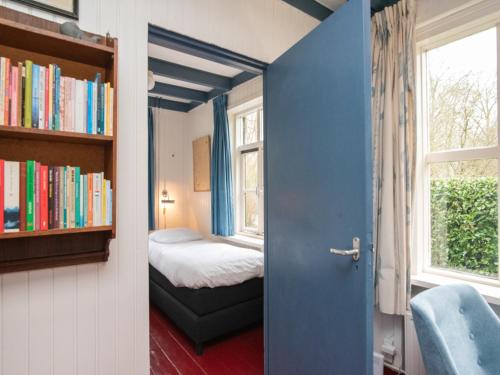 a room with a bed and a book shelf with books at Zandkamer in Vrouwenpolder