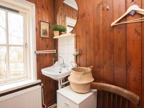 a bathroom with wooden walls and a sink at Zandkamer in Vrouwenpolder