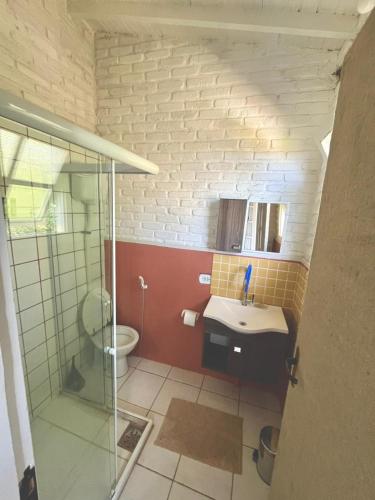 a bathroom with a toilet and a sink and a shower at Palmares, Casa Rustica Suites Buzios in Búzios