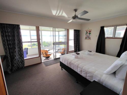 a hotel room with a bed and a balcony at Te Ra Waitangi in Paihia