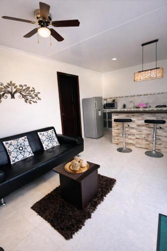 a living room with a black couch and a table at Posada Lkjay Providencia Isla in Providencia