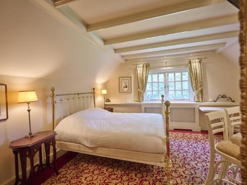 a bedroom with a bed and a desk and a window at Erve Het Klaashuis in Deurningen