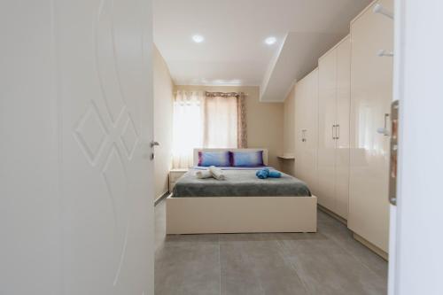 a bedroom with a bed with a blue pillow at koman_lakeview_apartments in Shkodër