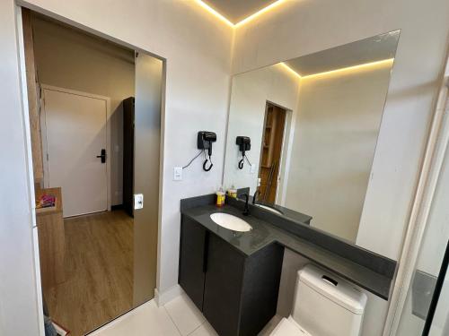 a bathroom with a sink and a mirror at Studios Botânico in Curitiba