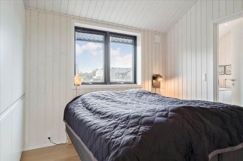 a bedroom with a large bed and a window at 30458-Odder-Strandvaenget-44 in Odder