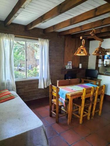 a dining room with a table and chairs and a window at Cabañas Blumenhaus in Villa Ventana