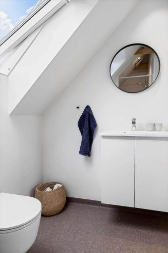 a bathroom with a white toilet and a mirror at 30467-Odder-Ravnsager-15 in Odder