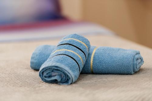 a blue rolled up towel on a bed at koman_lakeview_apartments in Shkodër