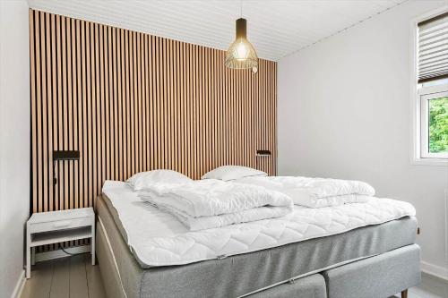 a bedroom with a bed with white pillows on it at 30320-Odder-Violvej-15 in Odder