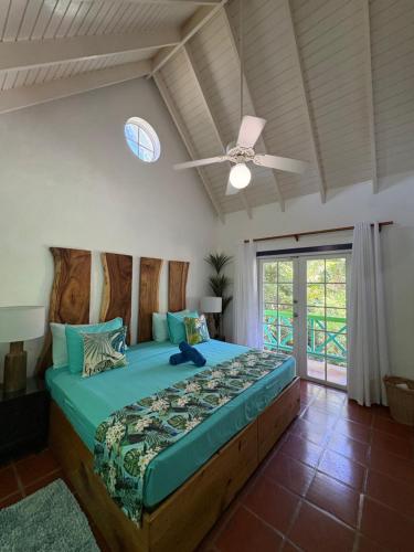 a bedroom with a bed with a ceiling fan at Reefside Villa in Crown Point