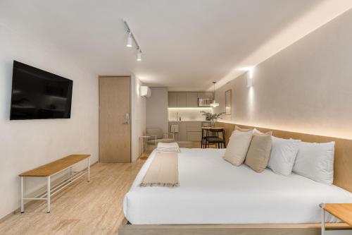 a bedroom with a large white bed and a kitchen at Casa Hugo by Capitalia in Mexico City