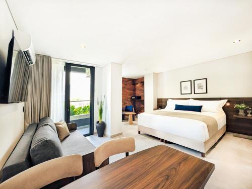 a bedroom with a bed and a couch at Laureles Selection Suites in Medellín