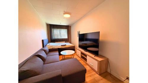 a living room with a couch and a flat screen tv at Cozy Room in the heart of Rødby! 5km from Femern & Puttgarden! in Rødby