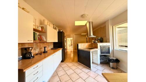 a kitchen with white cabinets and a counter top at Cozy Room in the heart of Rødby! 5km from Femern & Puttgarden! in Rødby