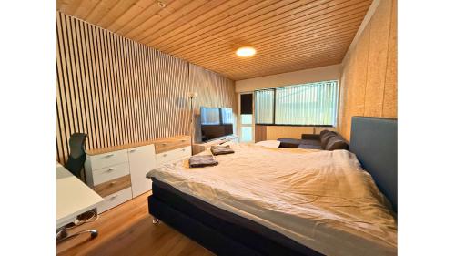 a bedroom with a large bed and a couch at Cozy Room in the heart of Rødby! 5km from Femern & Puttgarden! in Rødby