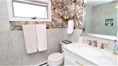 a bathroom with a sink and a toilet and a window at 3 Bedroomgorgeous Sunset Views!! in West Cape May