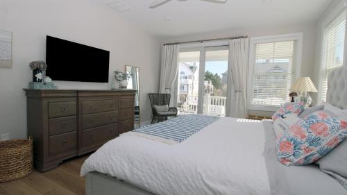 a bedroom with a bed with a television and a dresser at Seashell Sanctuary in Cape May