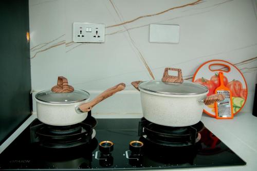 two pots on top of a stove in a kitchen at Ham Homes in Kampala