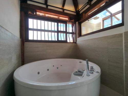 a bath tub in a bathroom with a window at Hotel Boutique El Carmel in Villa de Leyva