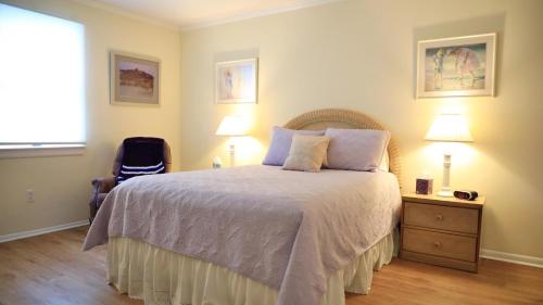a bedroom with a bed and two lamps and a window at Marilyns Cottage in Cape May