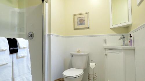 a white bathroom with a toilet and a shower at Marilyns Cottage in Cape May